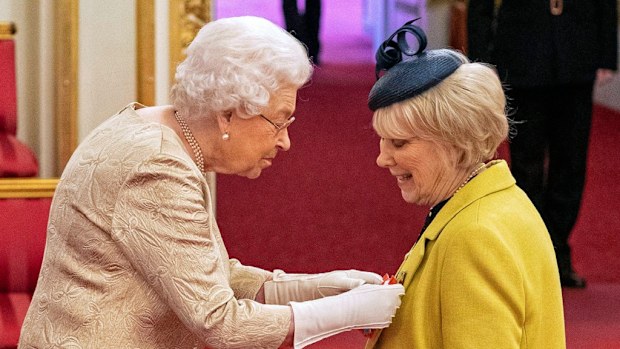 Queen Elizabeth II wears gloves as she awards the CBE actress Wendy Craig, during an investiture ceremony.