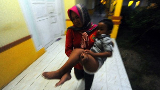 A paramedic carries the four-year-old Rafli, a survivor of a capsized ferry at a hospital in Siwa, Wajo, South Sulawesi. (EPA/STR)