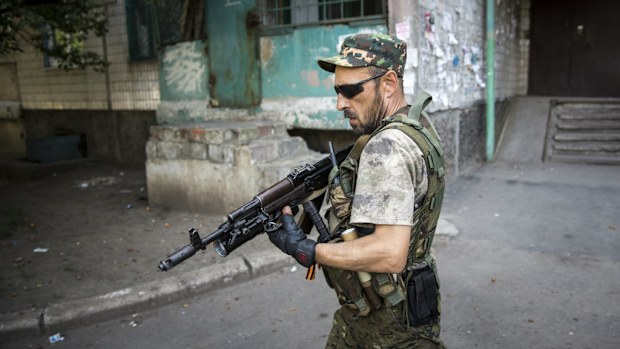 A pro-Russian rebel patrols a residential area close to the central railway station in Donetsk, Ukraine.
