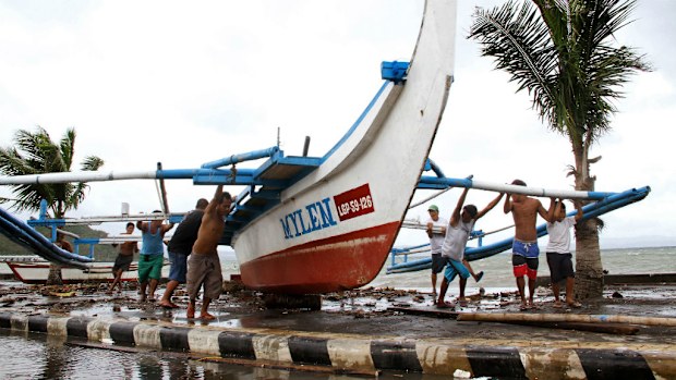 Fishermen carry an outrigger to higher ground in Legazpi City, south of Manila. (Getty Images)