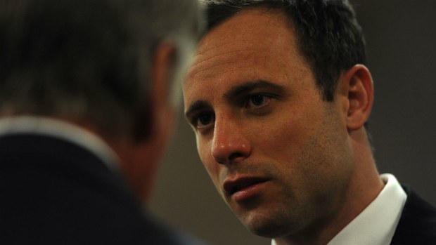 Oscar Pistorius speaks to a member of his defence team, in the Pretoria High Court. (Getty Images)