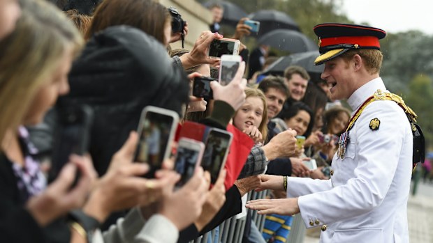 Prince Harry greets fans on his arrival in Australia.