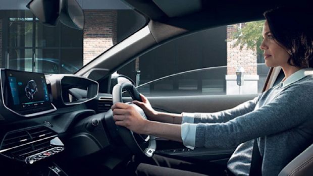Woman holding the steering wheel of car. 