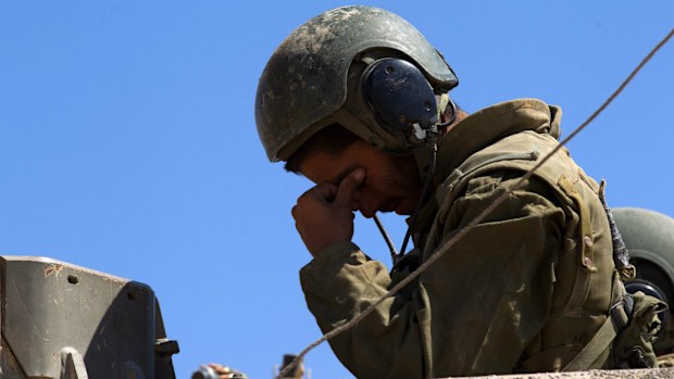 An Israeli soldier reacts as his tank leaves Gaza following heavy fighting. (AAP)