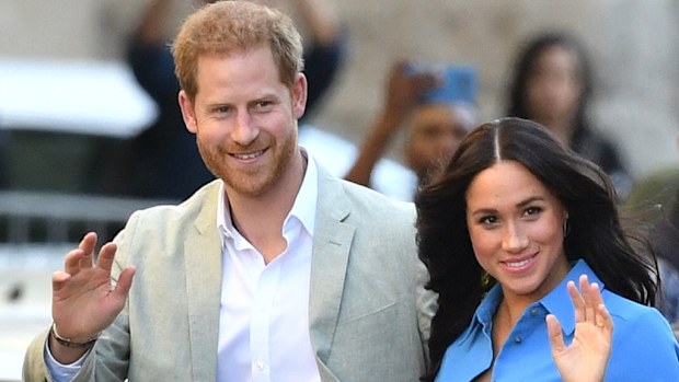 Prince Harry and Meghan Markle waving to crowd