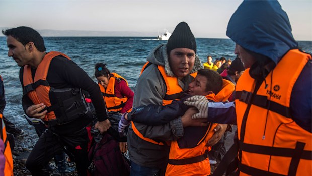 Refugees and migrants disembark from a dinghy after their arrival from the Turkish coast to the northeastern Greek island of Lesbos. (AAP)