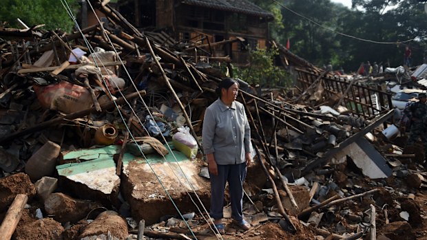 A woman stands amid collapsed houses at Longtoushan, in China's southwest Yunnan province following the earthquake. (Getty Images)
