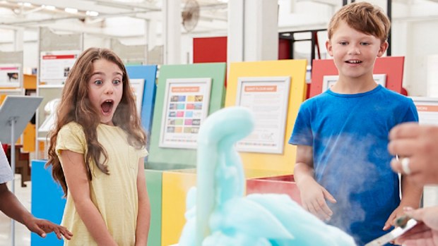 children watching a science experiment at a museum