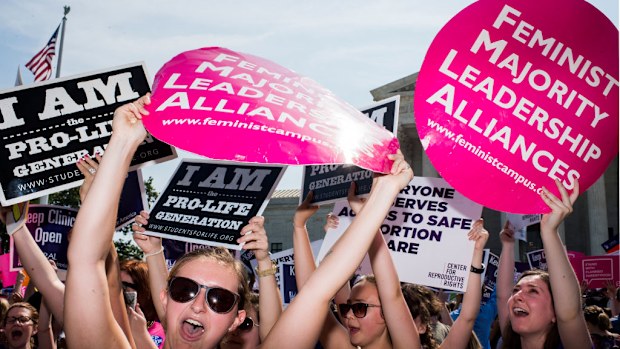 Pro-choice demonstrators at the U.S. Supreme Court cheer as they learn the court struck down the Texas abortion law (Getty)