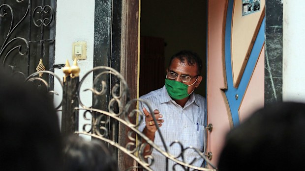A forensic expert looks from the door of a house in the Kasarvadavali area on the outskirt of Mumbai. (AAP)