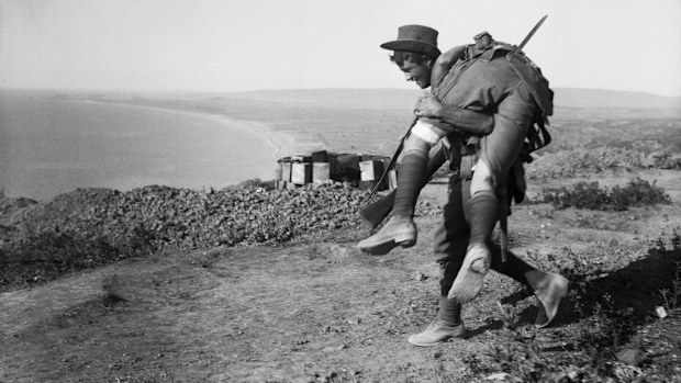 An Australian soldier carries a wounded mate to safety during the Gallipoli campaign. (Getty)