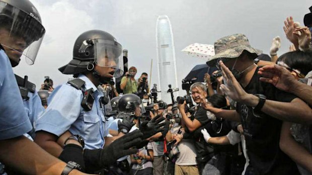  Riot police try to hold back protesters as an ambulance tries to leave the compound of the chief executive office in Hong Kong. (AP)