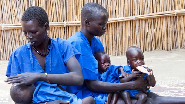 Two women hold their acutely malnourished children on March 4, 2017, in a stabilisation centre in Ganyiel, Panyijiar county, in South Sudan. South Sudan was declared the site of the world's first famine in six years, affecting about 100,000 people. (AFP)