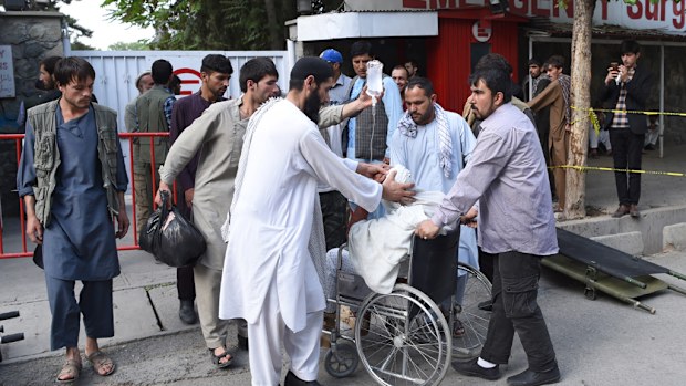 Afghan relatives push the wheelchair of a wounded man following a series of explosions that targeted the funeral of a politician's son who was killed during an anti-government, in Kabul. (AFP)