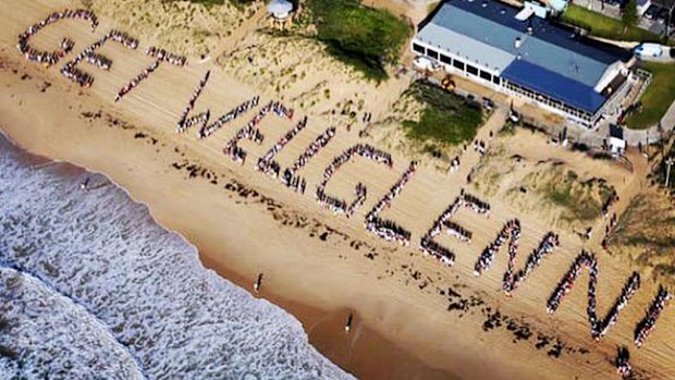 Hundreds of people line the beach in a message for Sydney media personality Glenn Wheeler. (Twitter/BenFordham)