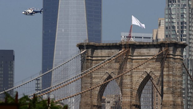 Vandals replaced the American flags on the Brooklyn Bridge with white banners of surrender. (AAP)