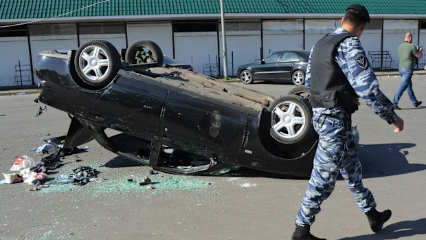 Two of the victims died after reportedly being run over by a car. (A car overturned at the Khovanskoye cemetery in Moscow after the brawl. (EPA/Vladimir Velengurin/ via AAP)