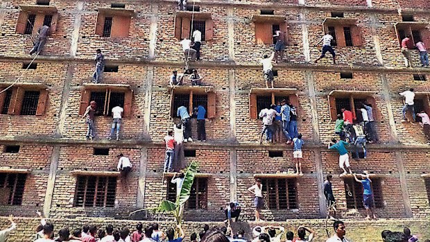 Relatives scale the walls to help students cheat in Hajipur, India. (AAP)
