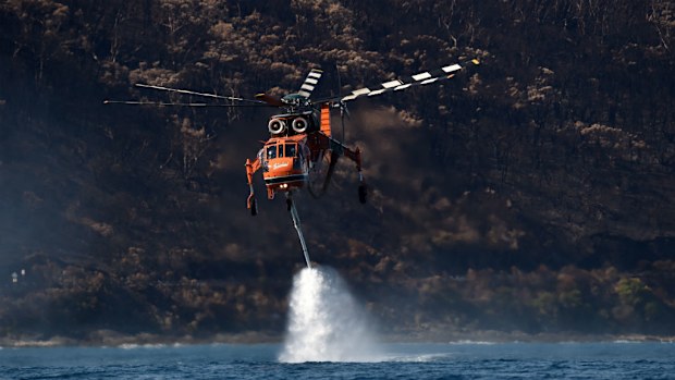 An Elvis helicopter picks up ocean water to protect homes from the Otaways bushfires. (AAP)