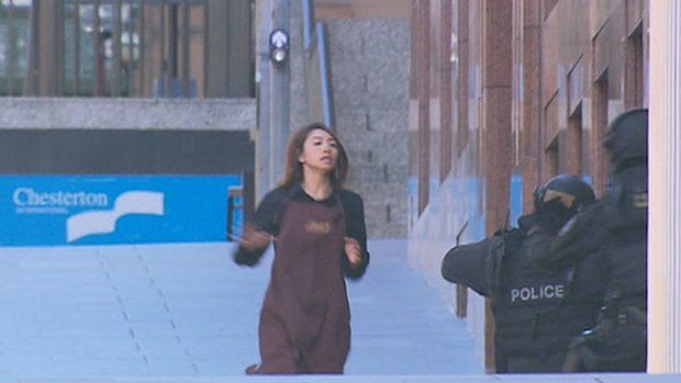 Elly Chen races for safety into the waiting arms of heavily armed police outside the Lindt cafe. (9NEWS)
