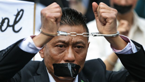 A protester handcuffed and gagged with tape participates in a rally across from the Indonesian embassy in central London in 2014 over political prisoners in West Papua. (AAP)