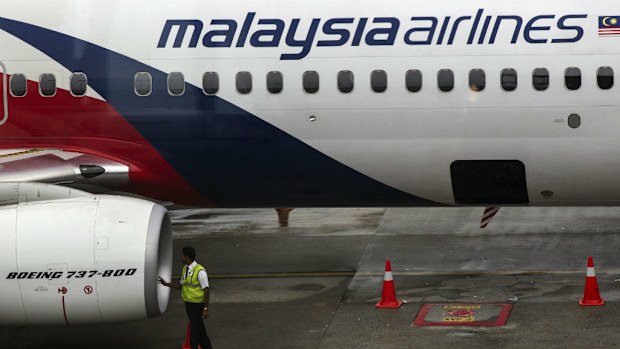 A Malaysia Airlines crew-member inspects the aircraft at Kuala Lumpur International Airport. (AAP)