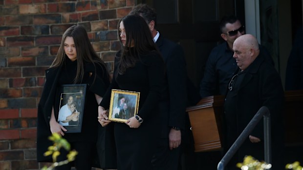 Carl Williams' daughter Dhakota Williams (left), and step-daughter Breanne Williams (second left), carry wreaths and photographs before the casket at the funeral for George Williams. (AAP)