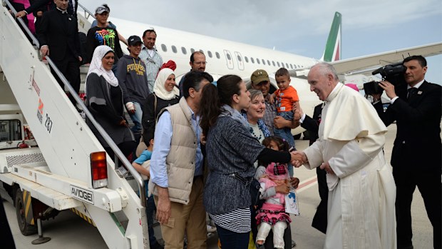  Pope Francis greets a group of Syrian refugees upon landing at Rome's Ciampino airport. (AAP)