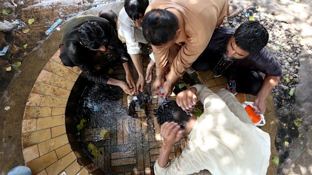 People cool off on a hot day in Karachi, Pakistan. (AAP)