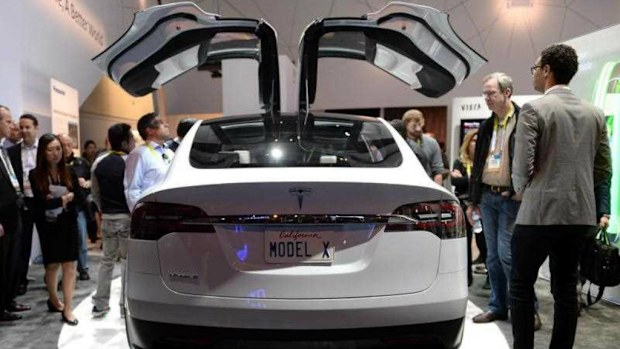 Visitors examine the concept car 'Model X' of electric powered cars manufacturer Tesla, on display at the stand of electonics manufacturer Panasonic during the 2015 International Consumer Electronics Show (CES) in Las Vegas, Nevada. (AP)