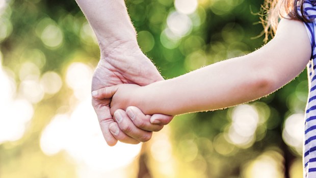 Dad holding daughter's hand