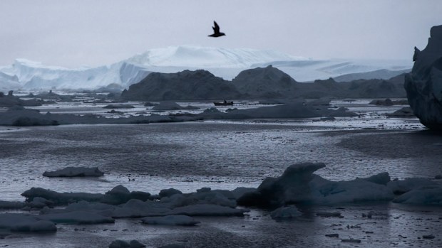 A fisherman drives a boat during Secretary of State John Kerry's tour of the Jakobshavn Glacier and the Ilulissat Icefjord, located near the Arctic Circle in Ilulissat, Greenland. (AAP)