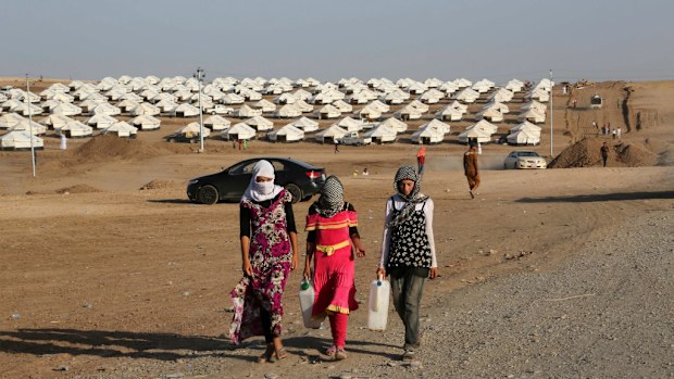 Displaced Iraqis from the Yazidi community settle at a new camp near the Syria-Iraq border, Iraq, Friday, Aug. 15, 2014. (AAP)