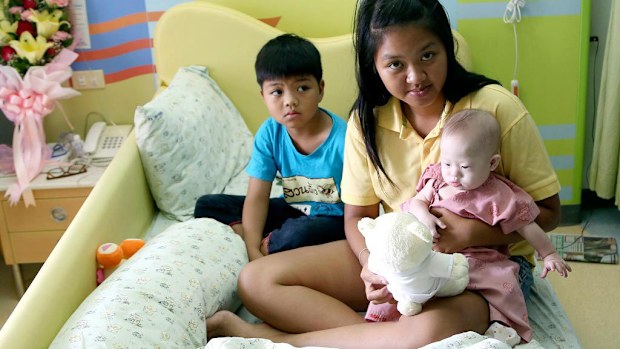 Pattaramon Chanbua, 21, poses with her children Game, 7, left, and baby boy Gammy. (AAP)