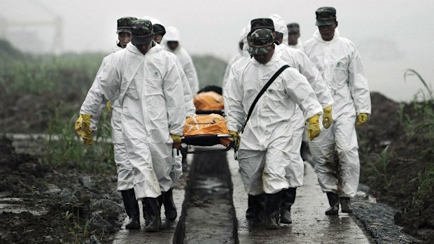 Rescuers carry the bodies of victims recovered from the capsized tourist ship in Yangtze River. (AAP)