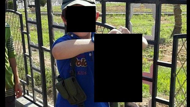 A photo shows the 7-year-old son of Khaled Sharrouf holding a severed head.