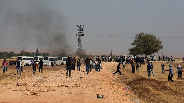 Kurdish demonsrators clash with Turkish security forces as thousands of Syrian refugees flee Islamic State militants. (AAP)