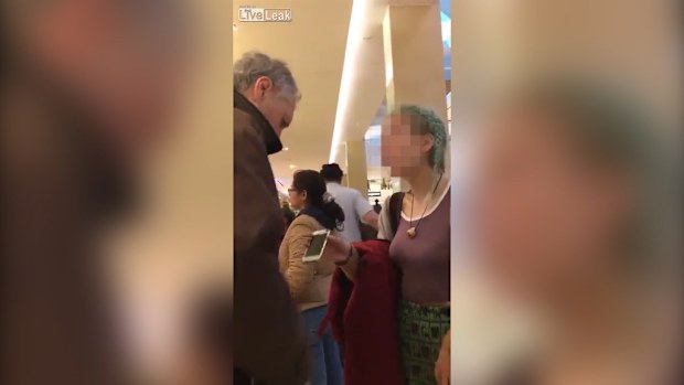 A girl has been filmed abusing a grey-haired man while waiting in a line at a shopping centre. (Liveleak/rickyfitts829)