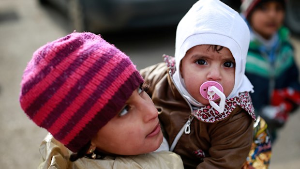 Syrian children wait for other members of their family after they crossed into Turkey on Saturday. (AAP)