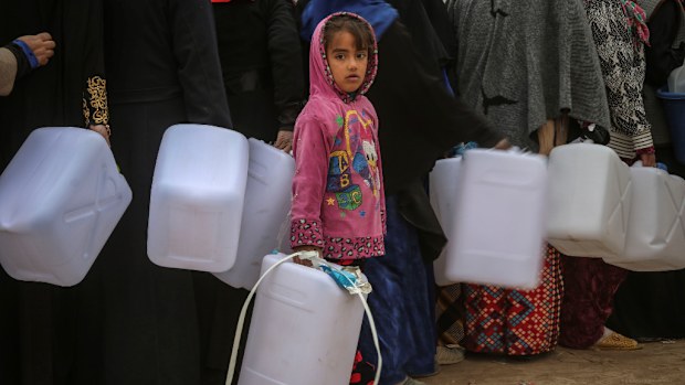 Iraqis, including children, queue for water as the city of Mosul plunges into drinkable water shortages. (AFP)