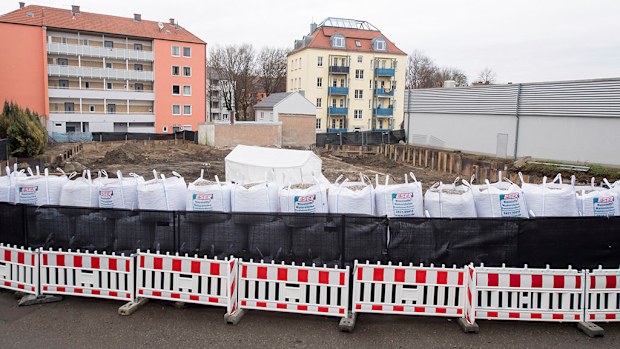 Sand bags and a fence are securing the location of the bomb site next to a construction site in Augsburg, Germany. (AAP)