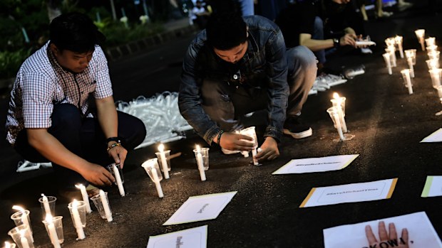 Indonesian men light candles during an anti-execution rally in front of the presidential palace yesterday in Jakarta. (AFP)