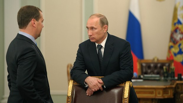Russian President speaks to his Prime Minister Dmitry Medvedev after a moment of silence for the victims of the MH17 tragedy. (AAP)