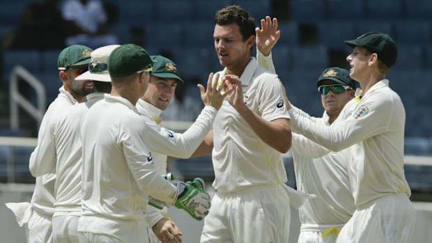 Josh Hazlewood is congratulated by teammates after taking the wicket of West Indies' Darren Bravo. (AAP)