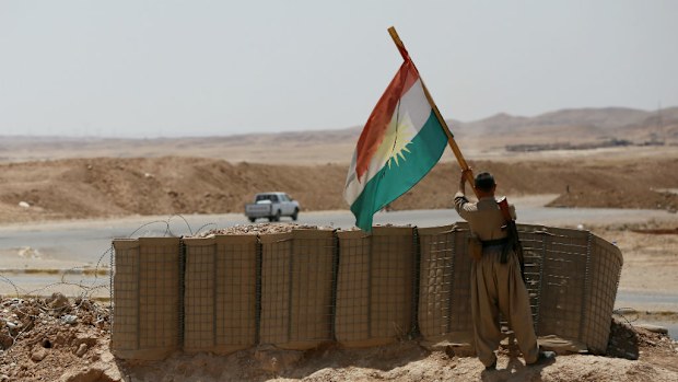 A peshmerga fighter puts up a Kurdish flag at a position near the strategic Jalawla area, which is a gateway to Baghdad. (Getty)