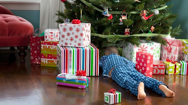 Boy looking under a Christmas tree