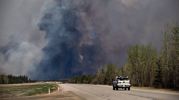 A truck drives toward a wildfire in Fort McMurray, Alberta. (AAP)