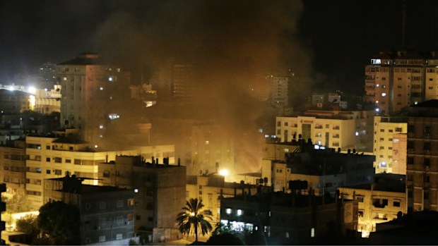 Smoke rises from a vehicle destroyed by an Israeli strike early on Saturday. (AAP)