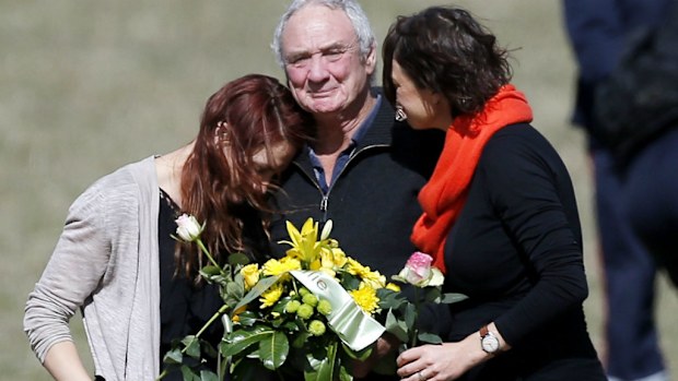 Malcolm Coram with daughters Philippa and Georgina at a memorial near the crash site. (AAP)