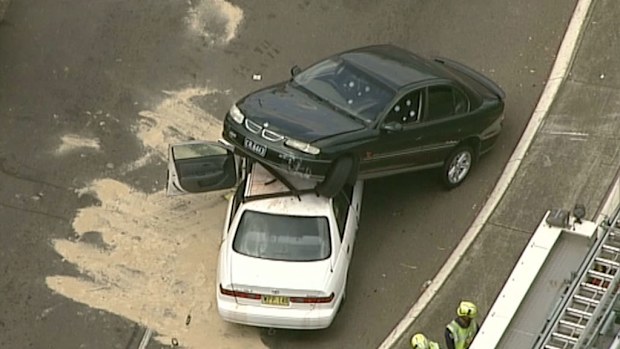 The dark-coloured sedan rests on top of the white sedan. (9NEWS)